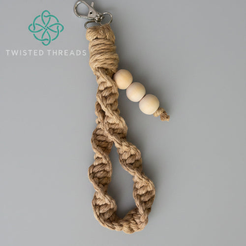 Beige medium macrame wristlet keychain from Twisted Threads Au with intricate knot details and a sturdy keyring.