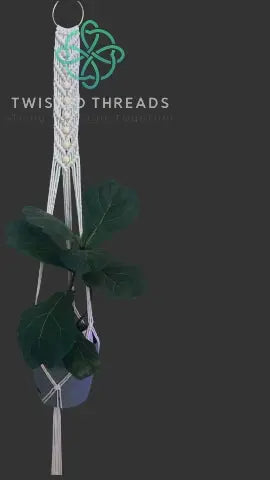 White macrame plant hanger with V shape and beads, signature design by Twisted Threads Au for holding potted plants.
