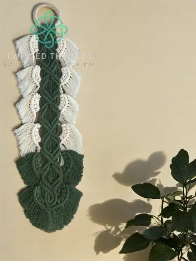 Macrame wall hanging with twisted olive leaf design by Twisted Threads Au, showcasing intricate knot work and natural olive leaf accents.